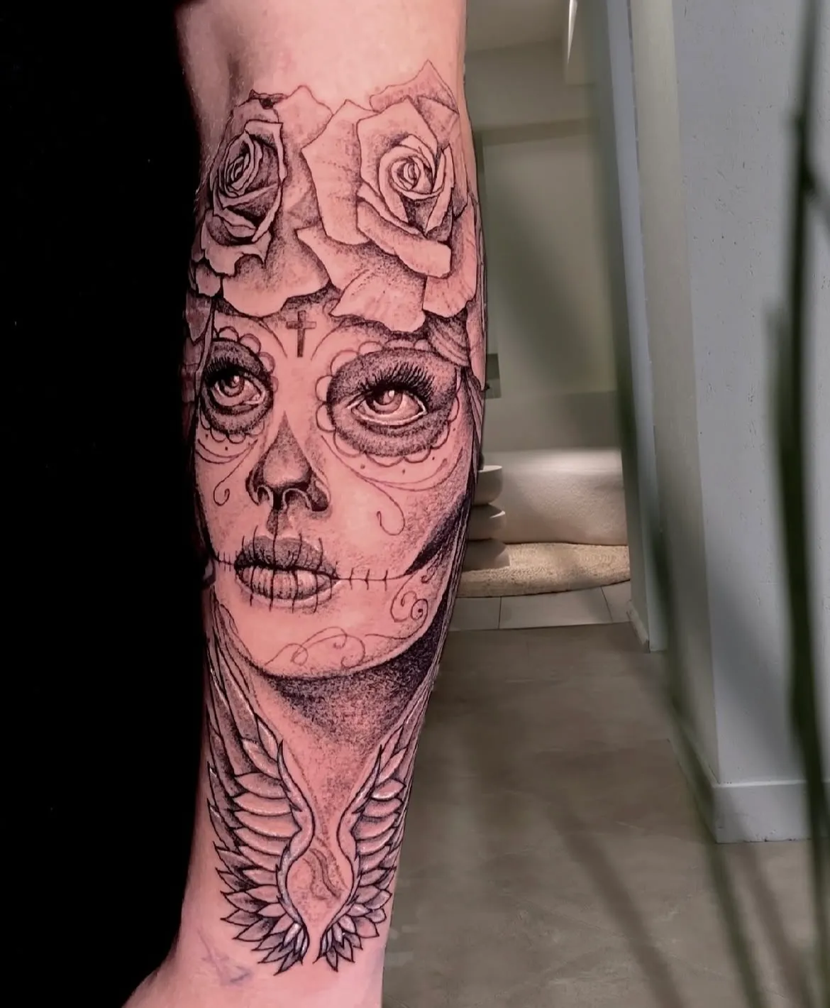 Detailaufnahme: Augen und Rosen des Catrina-Tattoos